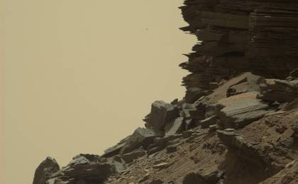 This view from Curiosity shows a dramatic hillside outcrop with sandstone layers that scientists refer to as "cross-bedding."