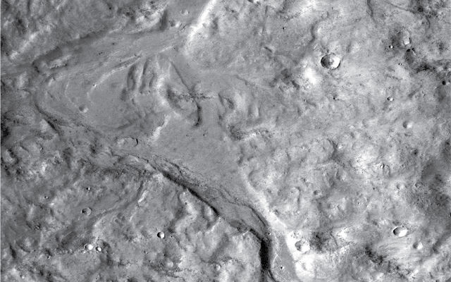 Streamlined forms in this Martian valley resulted from the outflow of a lake hundreds of millions years more recently than an era of Martian lakes previously confirmed. This image from the Context Camera on NASA's Mars Reconnaissance Orbiter covers an area in Arabia Terra about 8 miles wide.
