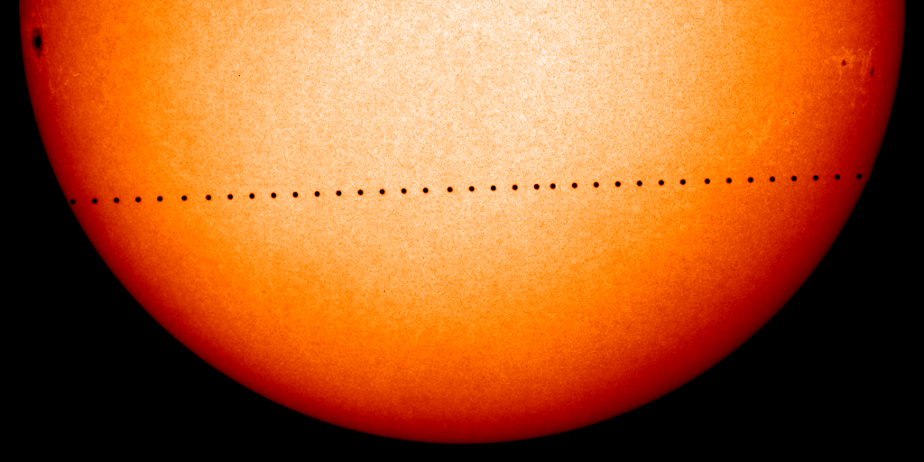 In transit, Mercury appears as a string of small black dots running across the orange disk of the Sun.