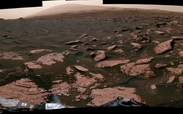 This 360-degree scene from the Mastcam on NASA's Curiosity Mars rover includes part of a linear-shaped dune the rover examined in early 2017 for comparison with what it found previously at crescent-shaped dunes. The view shows the dark, rippled surface of the active dune, near sedimentary bedrock.