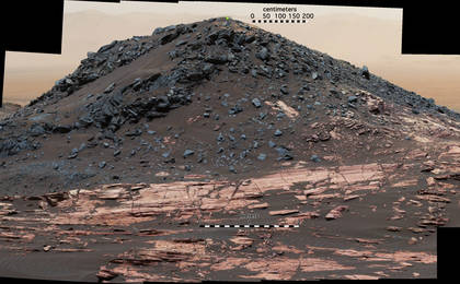 This view from the Curiosity Mars rover's Mastcam shows a dark mound, called "Ireson Hill," which rises about 16 feet above redder layered outcrop material on lower Mount Sharp, Mars, near a location where Curiosity examined a linear sand dune in February 2017.