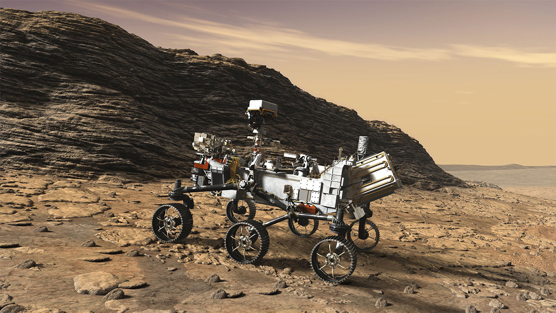 Perseverance rover near a rock formation, as it heads up a hill.