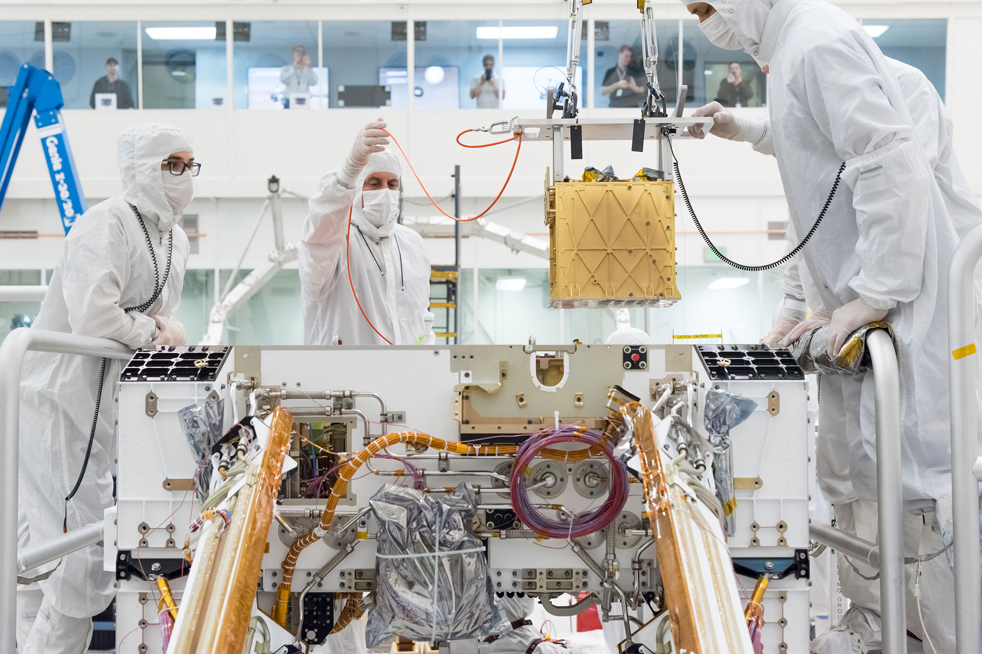 Members of NASA’s Mars 2020 project install the Mars Oxygen In-Situ Resource Utilization Experiment (MOXIE) into the chassis of NASA’s next Mars rover.