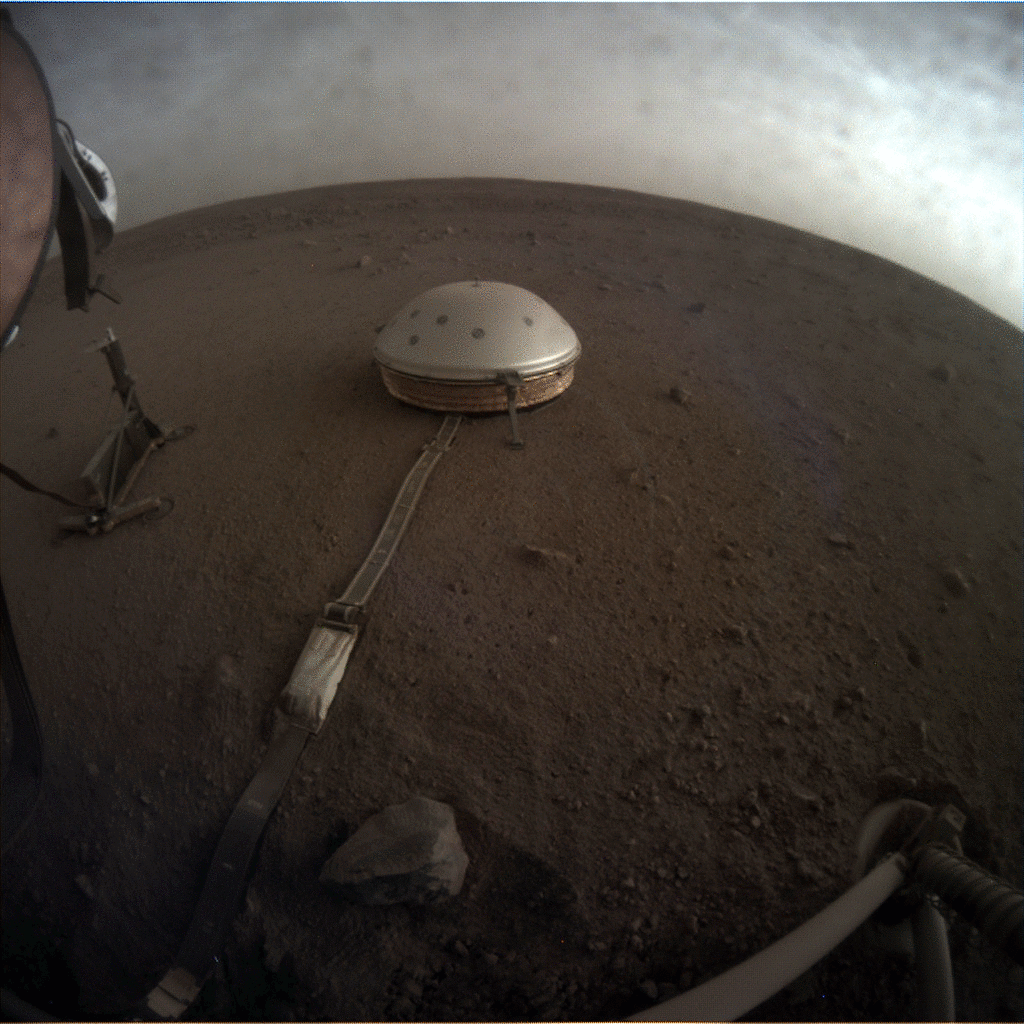 Dome-covered seismometer sits on the surface of Mars while clouds pass overhead.