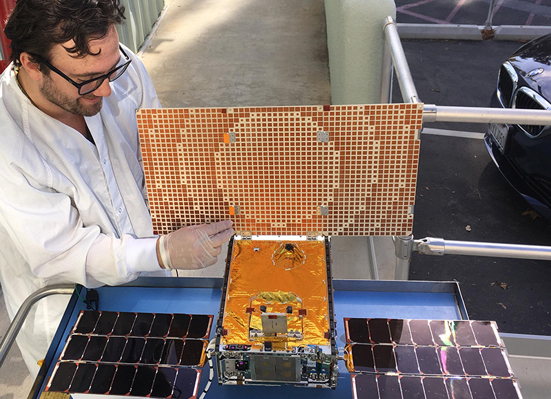 Engineer Joel Steinkraus uses sunlight to test the solar arrays on one of the Mars Cube One (MarCO) spacecraft at NASA's Jet Propulsion Laboratory. 
