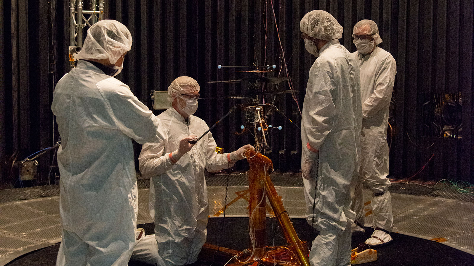 Members of NASA’s Mars Helicopter team prepare the flight model for a test in the Space Simulator,