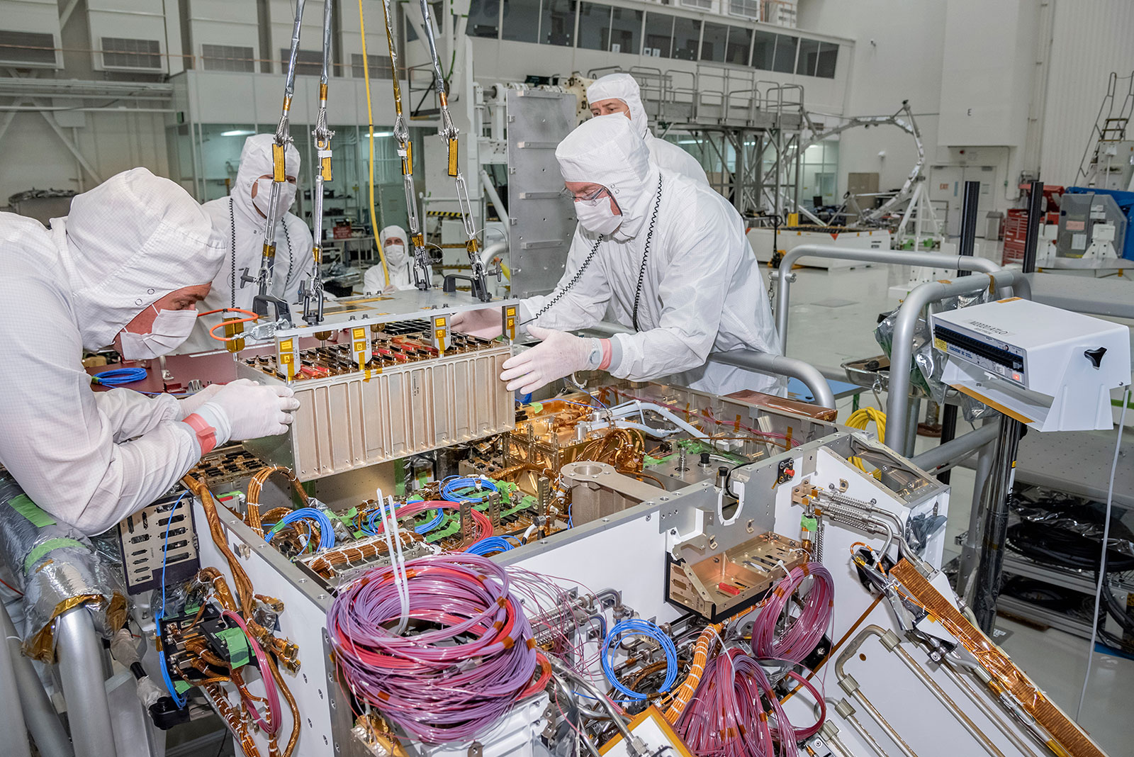 Technicians at JPL integrate the rover motor controller assembly (RMCA) into the Mars 2020 rover's body