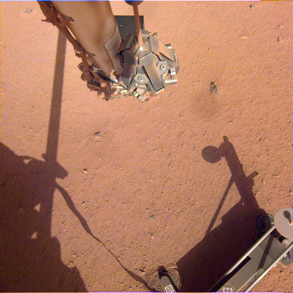 The robotic arm on NASA's Mars InSight lander moves in place over the Heat Flow and Physical Properties Package (HP3) and opens the fingers of its grapple in this series of images from June 1, 2019.