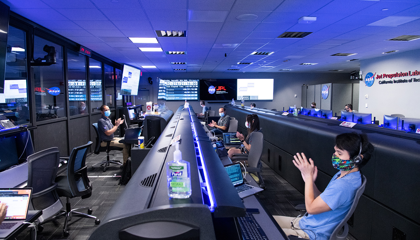 Engineers clapping during successful spacecraft maneuver