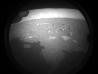 This is the first image NASA’s Perseverance rover sent back after touching down on Mars on Feb. 18, 2021. The view, from one of Perseverance’s Hazard Cameras, is partially obscured by a dust cover.