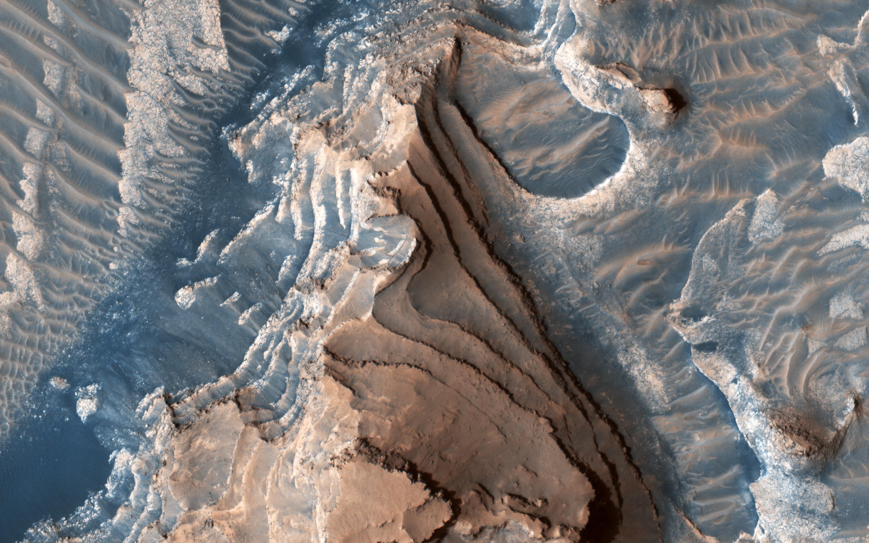This image acquired on March 21, 2019 by NASAs Mars Reconnaissance Orbiter, shows an eroded mesa made up of rhythmically layered bedrock that seems to indicate cyclic deposition.