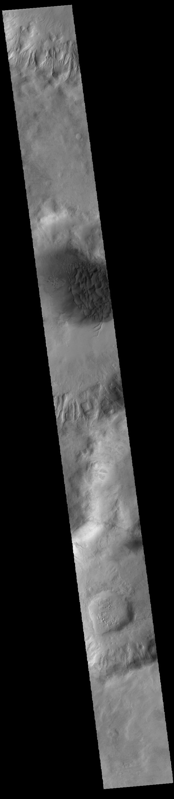 This image from NASAs Mars Odyssey shows a large sand sheet with surface dune forms as well as smaller sand dunes within an unnamed crater in Noachis Terra.