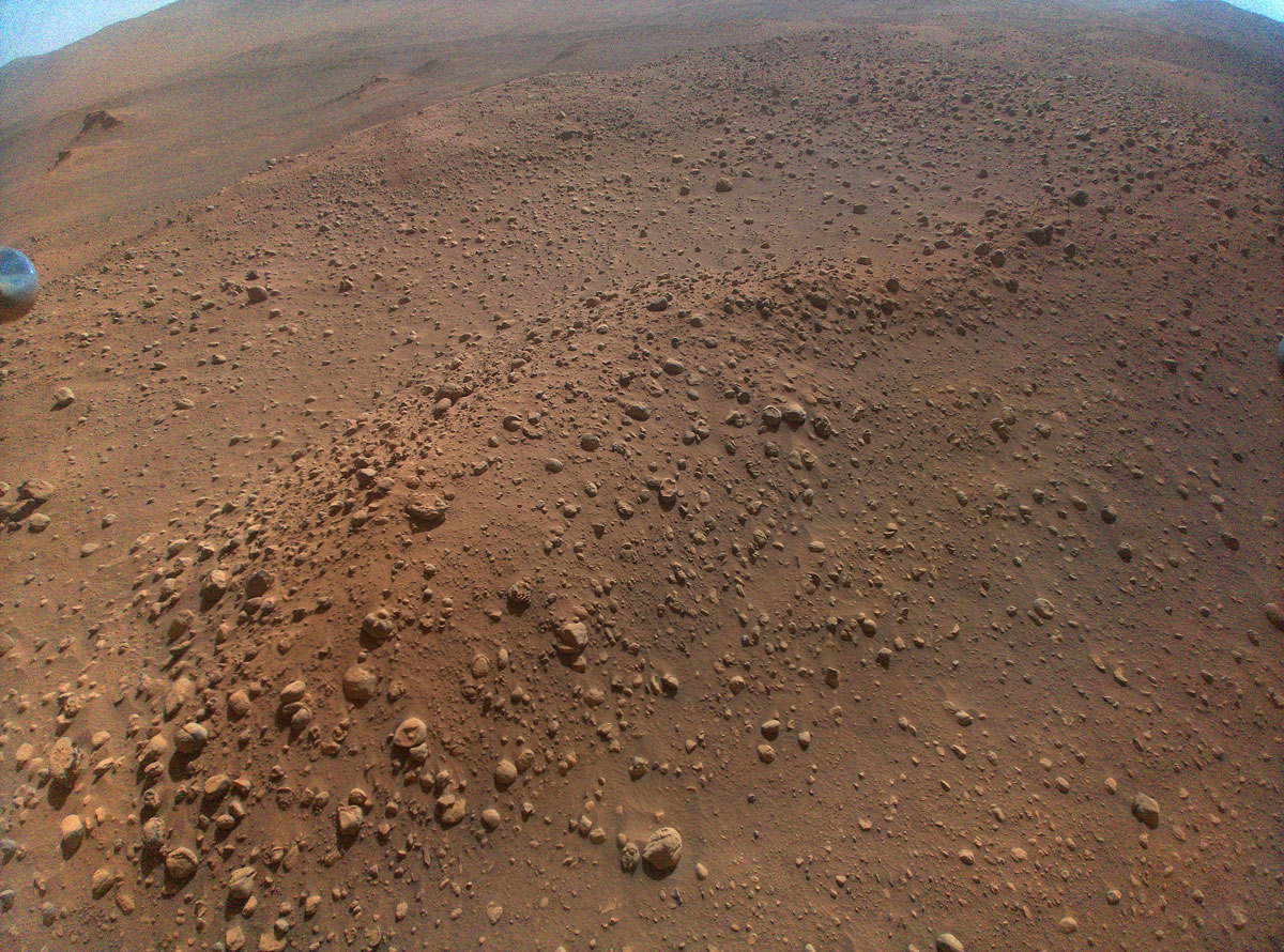 Der Ingenuity Mars Helicopter der NASA hat dieses Bild mit seiner hochauflösenden Farbkamera aufgenommen.  Diese Kamera ist im Rumpf des Hubschraubers montiert und etwa 22 Grad unter den Horizont gerichtet.