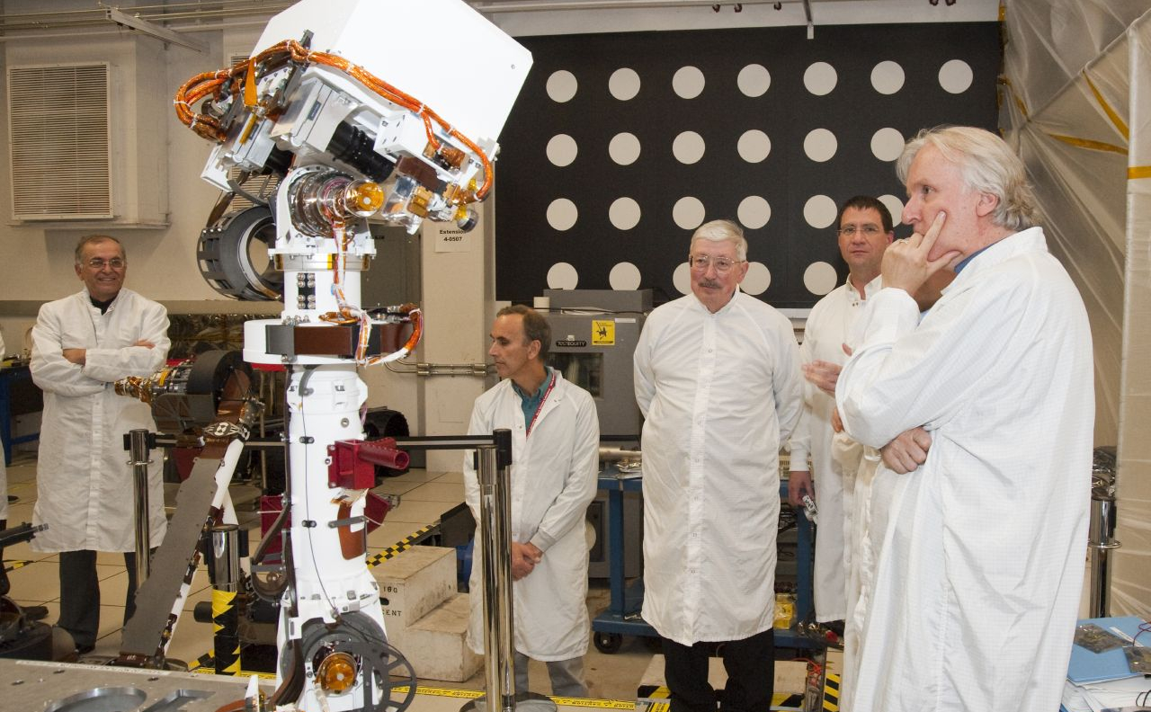 A group watching motions of an engineering model of the camera mast for NASA's Mars rover Curiosity on March 5, 2010, includes moviemaker James Cameron (right).