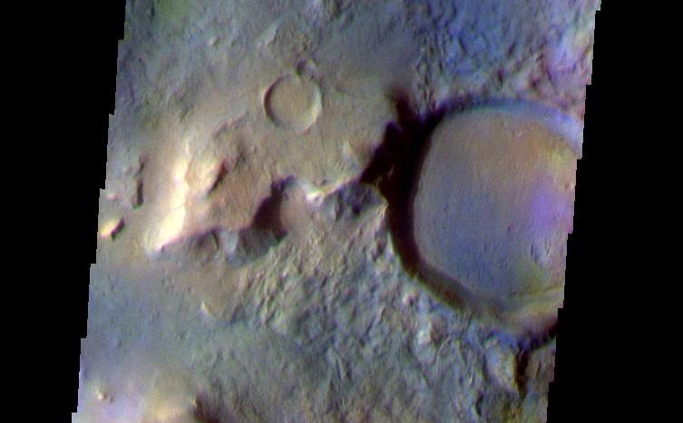 This false color image shows a region with craters of different ages located at the margin of Acidalia Planitia. This image was collected during the Northern Spring season. The THEMIS VIS camera is capable of capturing color images of the Martian surface using five different color filters. In this mode of operation, the spatial resolution and coverage of the image must be reduced to accommodate the additional data volume produced from using multiple filters. To make a color image, three of the five filter images (each in grayscale) are selected. Each is contrast enhanced and then converted to a red, green, or blue intensity image. These three images are then combined to produce a full color, single image. Because the THEMIS color filters don't span the full range of colors seen by the human eye, a color THEMIS image does not represent true color. Also, because each single-filter image is contrast enhanced before inclusion in the three-color image, the apparent color variation of the scene is exaggerated. Nevertheless, the color variation that does appear is representative of some change in color, however subtle, in the actual scene. Note that the long edges of THEMIS color images typically contain color artifacts that do not represent surface variation.