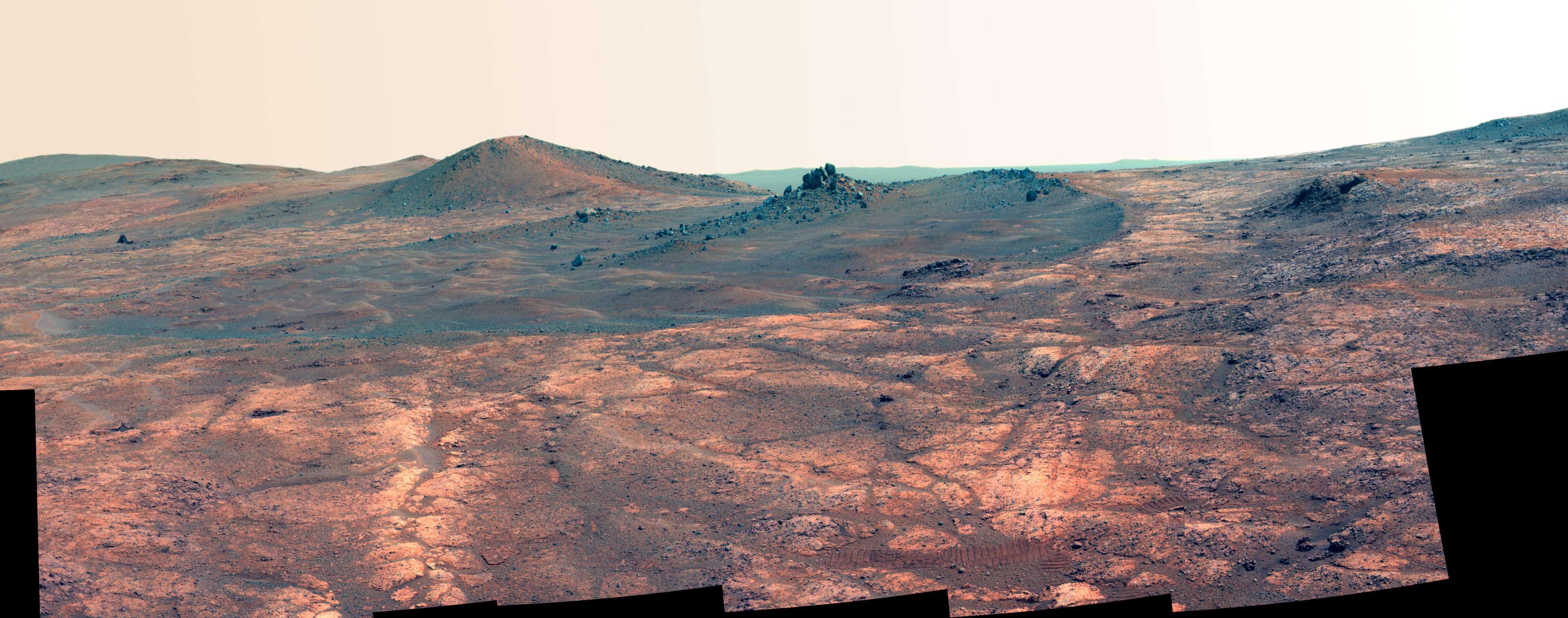 An elongated crater called "Spirit of St. Louis," with a rock spire in it, dominates this scene from the panoramic camera (Pancam) on NASA's Mars Exploration Rover Opportunity.