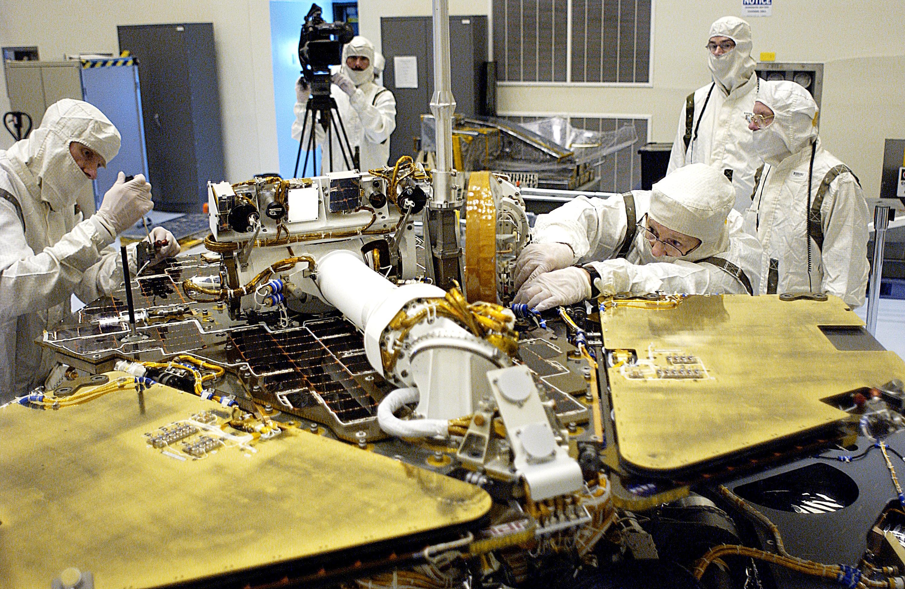 In the Payload Hazardous Servicing Facility, technicians remove one of the circuit boards on the Mars Exploration Rover 2 (MER-2).