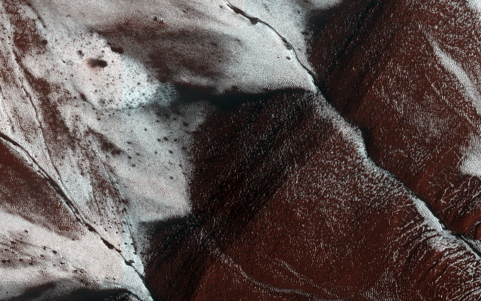 This HiRISE image shows gullies on a south-facing slope of a crater touched with late-Spring carbon dioxide frost.