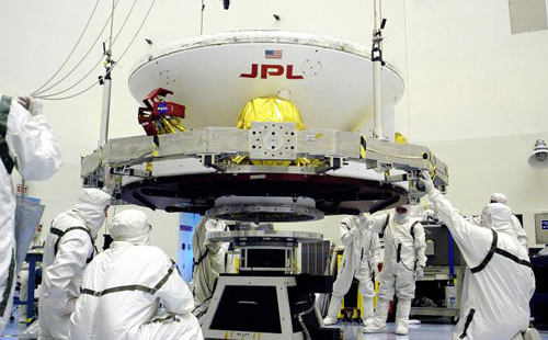 Engineers work on Opportunity (in its cruise configuration) in a cleanroom at Kennedy Space Center.   A very important part of planetary protection is keeping contaminants from humans from riding aboard spacecraft.  The pictured engineers are donning "bunny suits" that only allow their  eyes to be exposed.