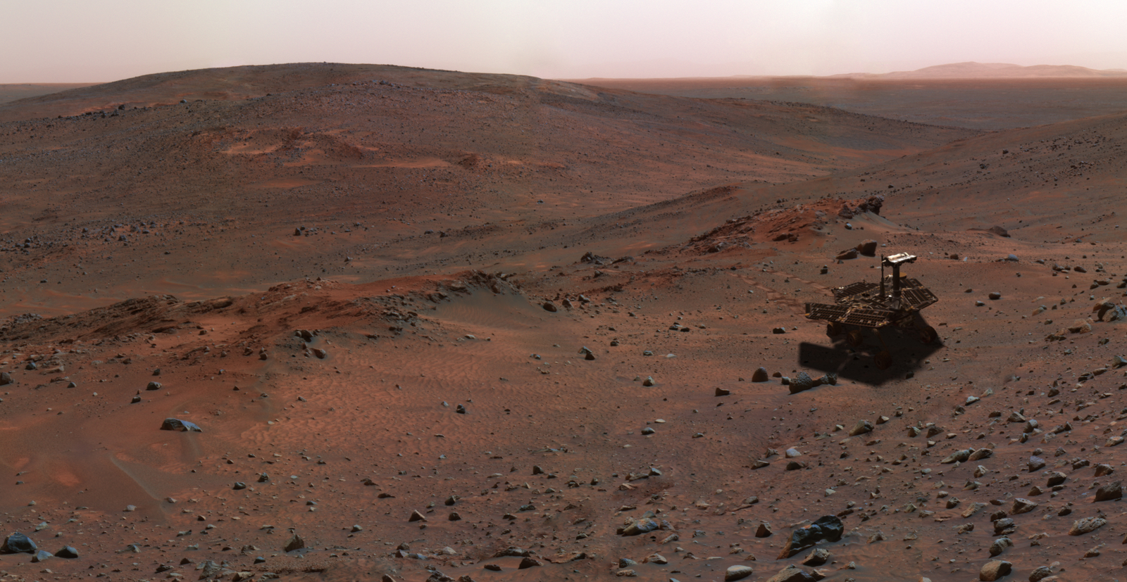 This synthetic image of the Spirit Mars Exploration Rover on the flank of "Husband Hill" was produced using "Virtual Presence in Space" technology.