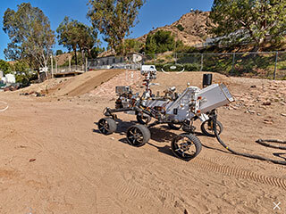 While NASA’s Perseverance Mars rover makes groundbreaking achievements on the Red Planet, its twin is hard at work in JPL’s Mars Yard. The Operational Perseverance Twin for the Integration of Mechanisms and Instruments Sent to Mars, or OPTIMISM, is the Mars 2020 Vehicle System Testbed (VSTB) rover.