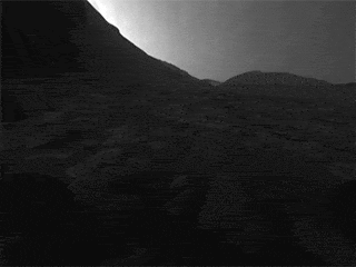 While stationary for two weeks during Mars solar conjunction in November 2023, NASA’s Curiosity rover used its front and rear black-and-white Hazcams to capture 12 hours of a Martian day. The rover’s shadow is visible on the surface in these images taken by the front Hazcam.